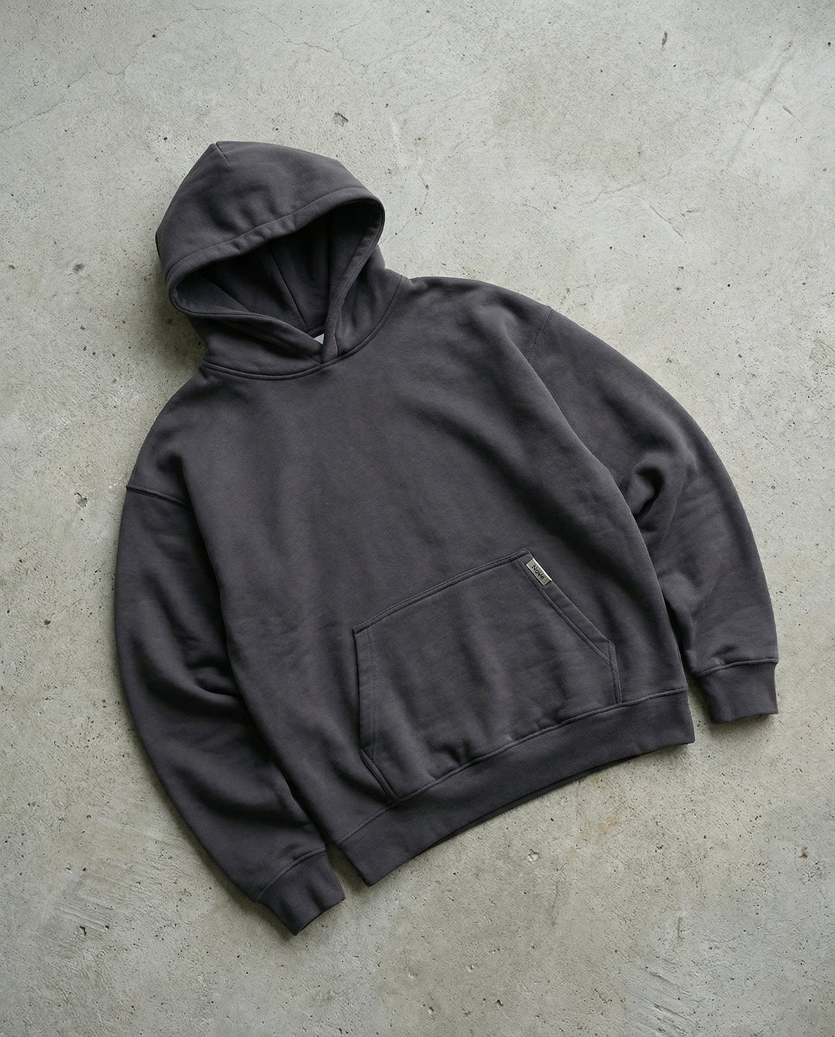 charcoal grey hoodie on a concrete floor