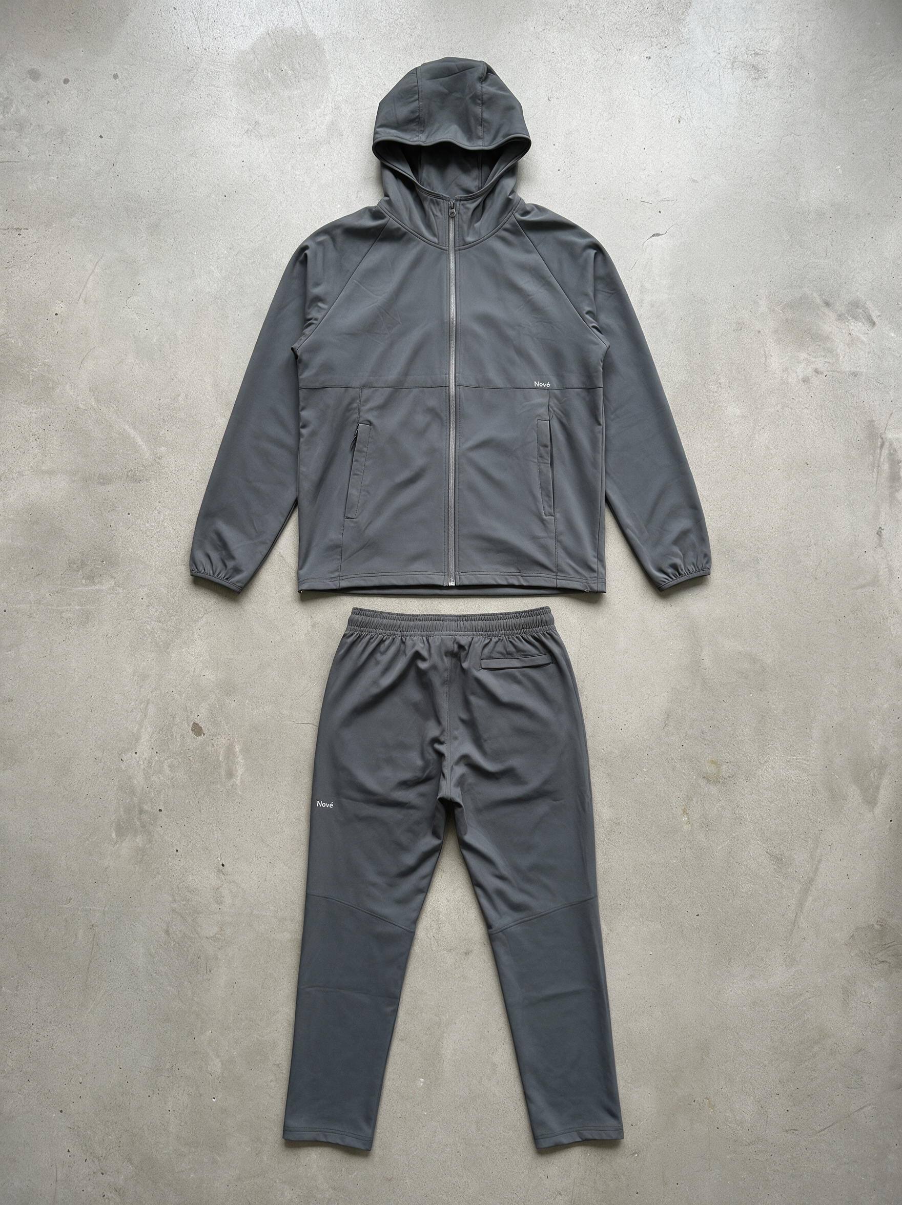 Steel Motion jacket and track pants laid flat on concrete